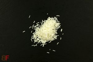Gekochter Reis in der Pfanne oder in der Mikrowelle erhitzen, auf einem Teller anrichten.