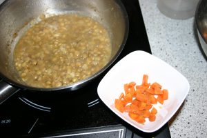 Bevor die Linsen in die Gemüsebrühe gegeben werden, die Karottenwürfel mit etwas Flüssigkeit entnehmen und in einem getrennten Topf ca. 3 Min. angaren. Die Karotten werden getrennt gereicht.