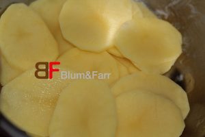 Die Kartoffeln mit einer Reibe in ca. 1 mm dicke Scheiben schneiden.